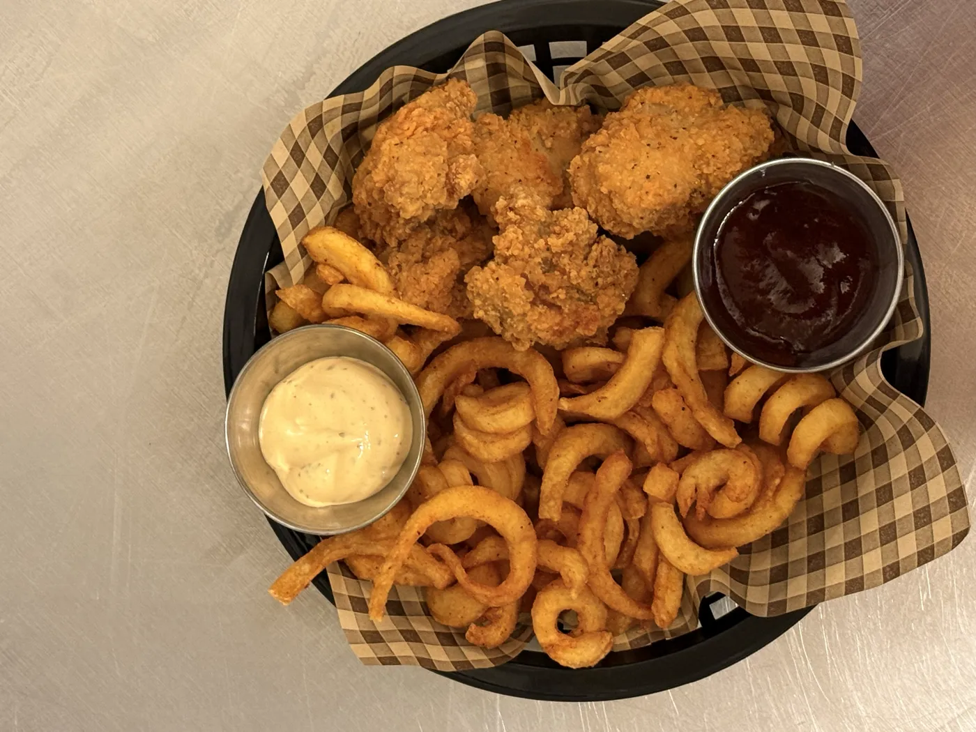 Curly Fries mit Crispy Fried Chicken und zwei Dips im Körbchen